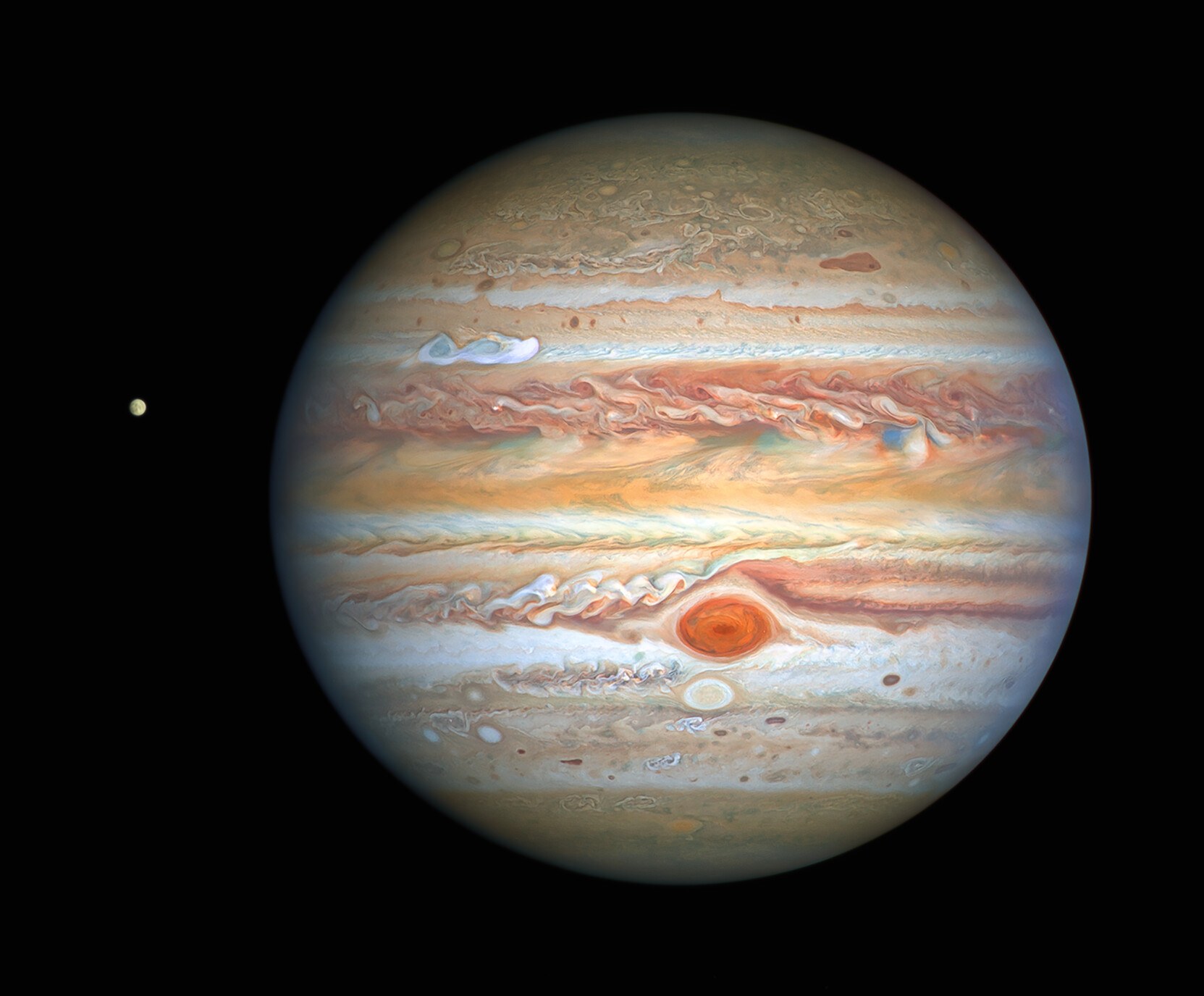 Hubble view of Jupiter filling the left of the frame: a limb of cream and rust cloud bands against magnetic dark.